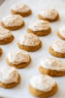 pumpkin gluten free cookies frosted with brown sugar icing on white background