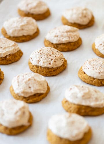 pumpkin gluten free cookies frosted with brown sugar icing on white background